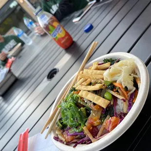 a bowl of salad and chopsticks