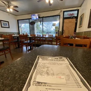 Restaurant dining area with a boarded up front door from a previous break-in. I hope they finally get around to fixing it.
