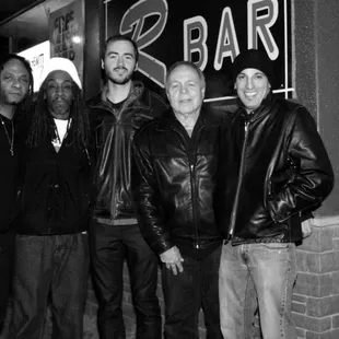 a group of men standing in front of a bar