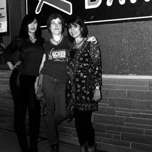 three women standing in front of a bar