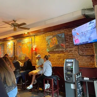 people sitting at tables and watching television