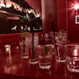 a row of glasses on a red table