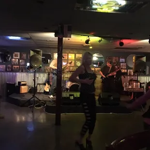 a woman playing a guitar in a bar