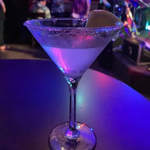 a martini with a lime garnish on the rim
