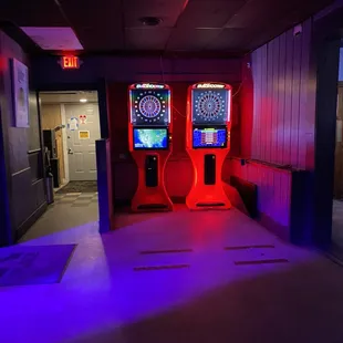 two arcade machines lit up at night