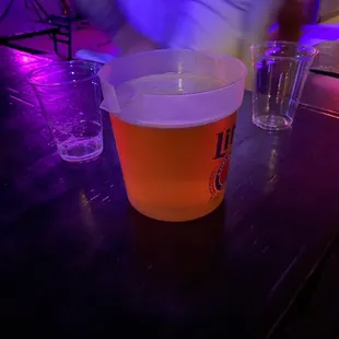 a person pouring a drink into a plastic cup
