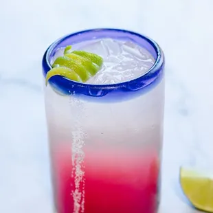 a drink with a lime garnish