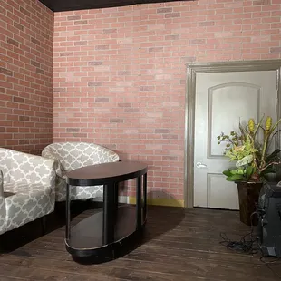 two chairs and a table in front of a brick wall