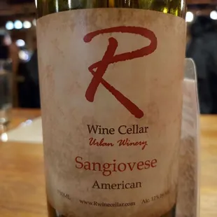 One of their own bottles as a vase for dried flowers on the table