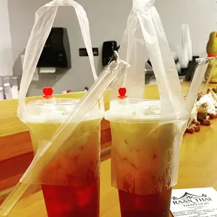 two drinks in plastic cups on a table