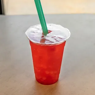 a red drink with a green straw
