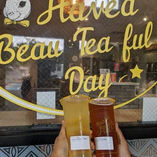 a person holding two cups of tea