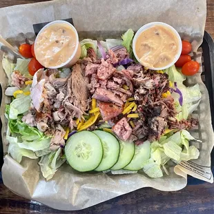 Rabel's Salad with chopped prime brisket, pulled pork, sausage, turkey, and homemade thousand island dressing