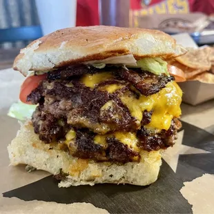 Double prime brisket burger with cheese and bacon on a jalapeño bun. Get this!