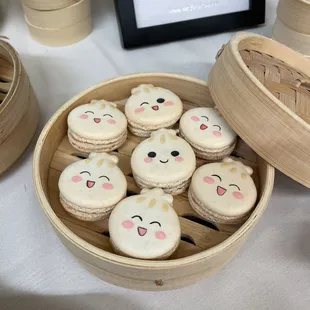 a basket of macarons with faces on them