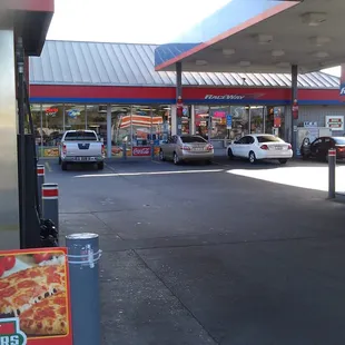 a gas station with cars parked in front of it