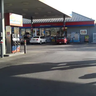 a gas station with cars parked in the lot