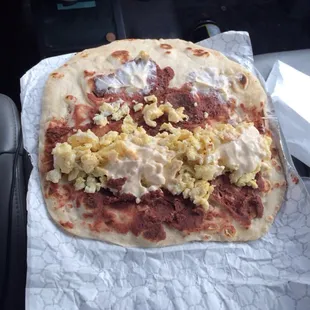 an uncooked pizza on a piece of paper