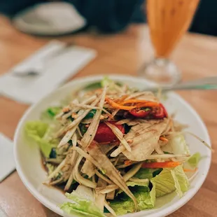 a plate of salad and a glass of orange juice