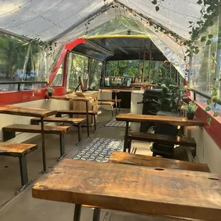 the inside of a tent with tables and benches