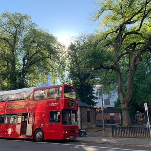 a red double decker bus on a city street