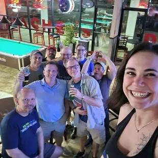 a group of people at a pool table