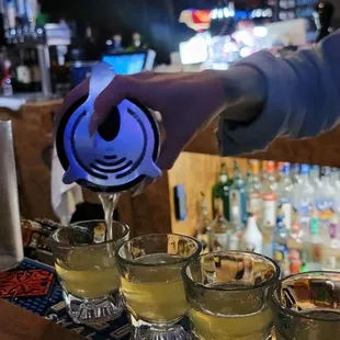 a person pouring a drink at a bar