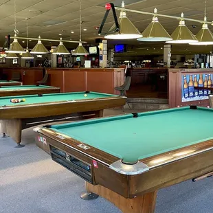 Island style bar with pool tables that surround.