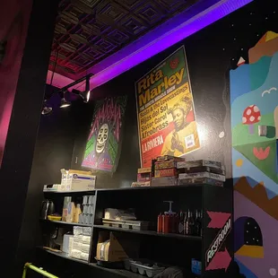 a bar with neon lights and posters on the wall