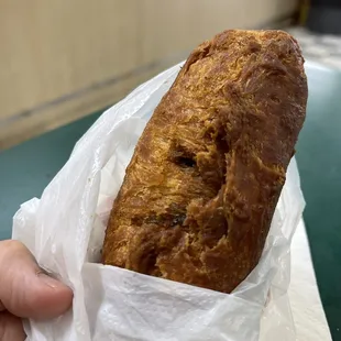 a hand holding a loaf of bread