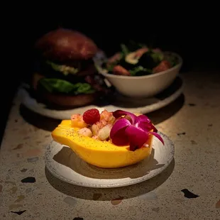 Fresh side of fruit served in a papaya bowl sprinkled with crystalline hibiscus!
