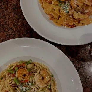 two plates of pasta and shrimp
