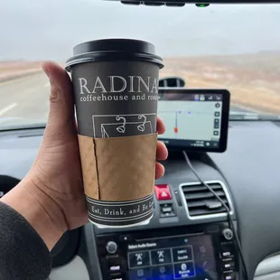 a hand holding a coffee cup