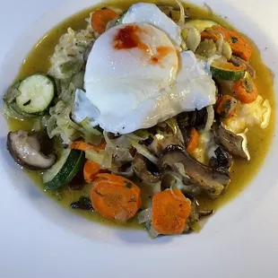 a bowl of soup with an egg on top