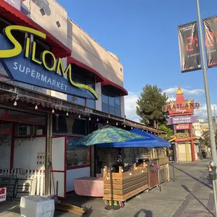 Located in front of the Silom Supermarket on the sidewalk along the street