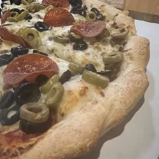 a pizza with olives and pepperoni