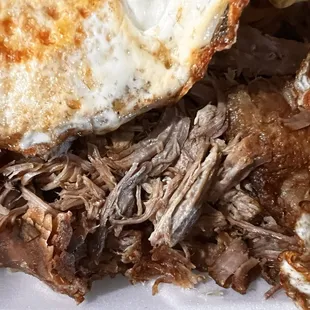 Carnitas, beans cheese  and rice , fried eggs