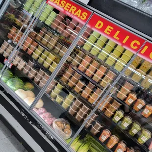 a refrigerated display of fresh fruits and vegetables
