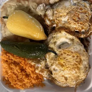 Fried eggs, beans, and cheese, rice, and Carnitas