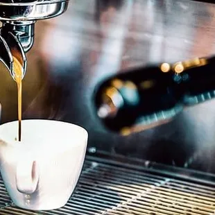 coffee being poured into two cups