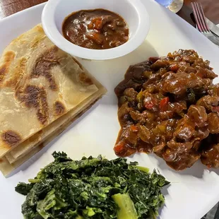 Flat bread, beef stew, and collard greens.