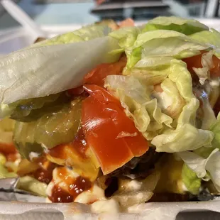 Bunless cheeseburger with extra patty, grilled onions, lettuce, tomato, pickles, ketchup and mayo.