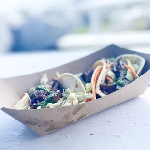 two tacos in a paper container