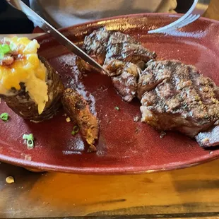 a man cutting a steak with a knife