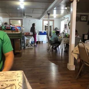 a man sitting at a table with a box of pizza in front of him