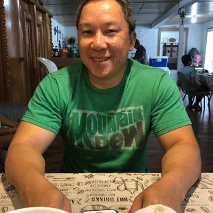 a man sitting at a table with a cell phone in front of him