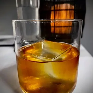 a glass of whiskey with a lemon wedge