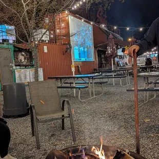 a man standing in front of a fire pit