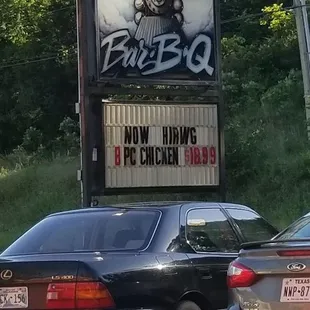 cars parked in front of a sign