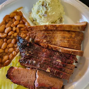 a plate of meat, beans, and mashed potatoes